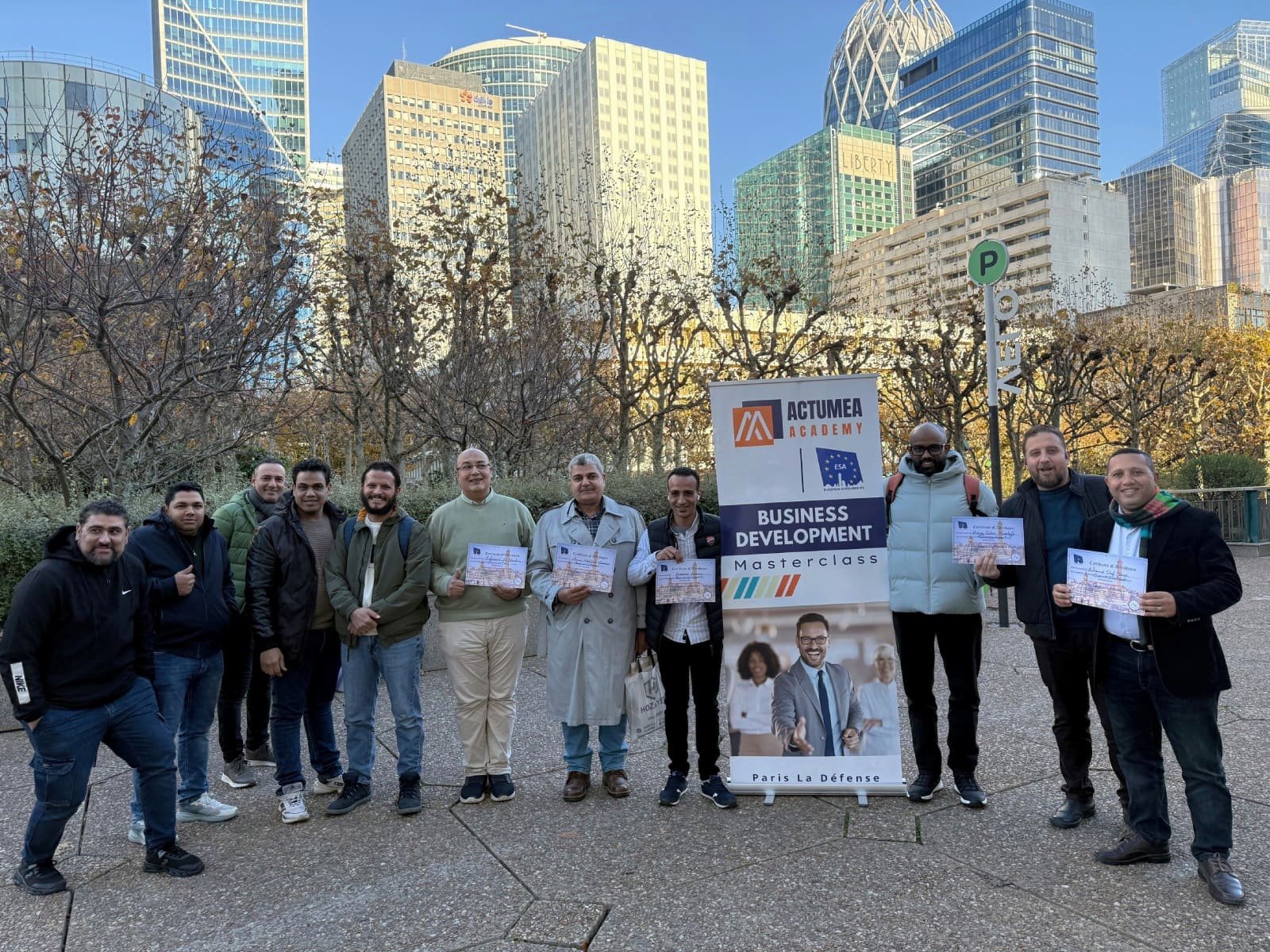 ESA participants holding certificates beside an ESA and Actumea Academy banner during a professional preparation session in Paris La Défense